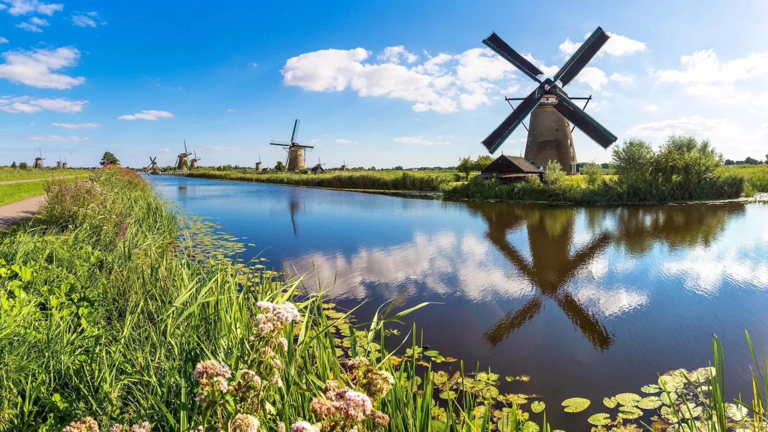Windmills reflected in still water at Kinderdijk in the Netherlands